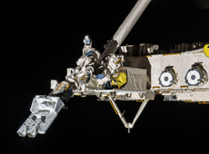 「きぼう」のロボットアームに把持された衛星放出システム（提供：JAXA/NASA）