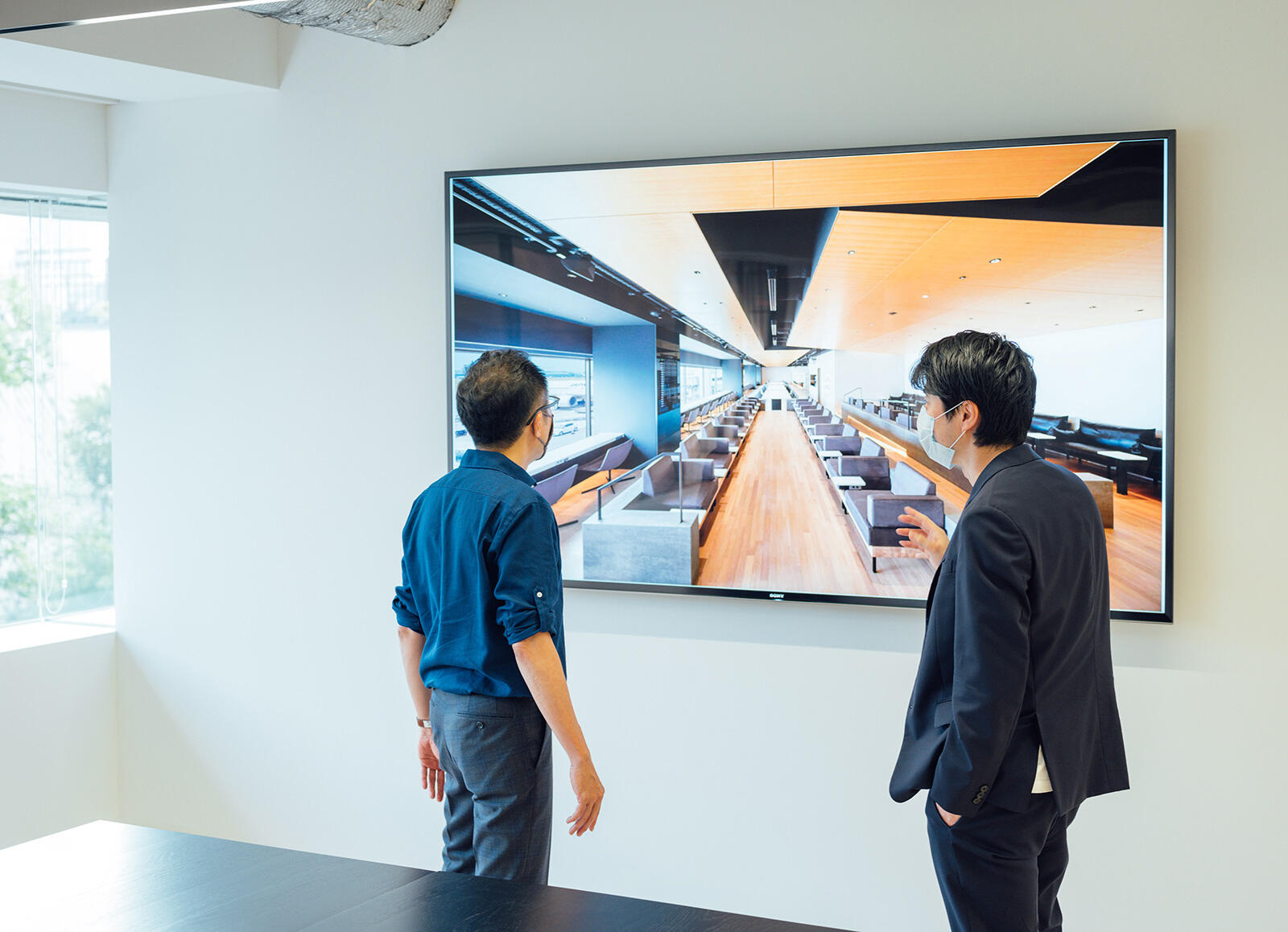 対談は田川さんが代表を務めるTakramのオフィスにて行った。スクリーンに映っているのは、羽田空港の有料ラウンジである「POWER LOUNGE」。 Takramは同場所のクリエイティブディレクションを日本デザインセンターおよび原デザイン研究所と担当。
