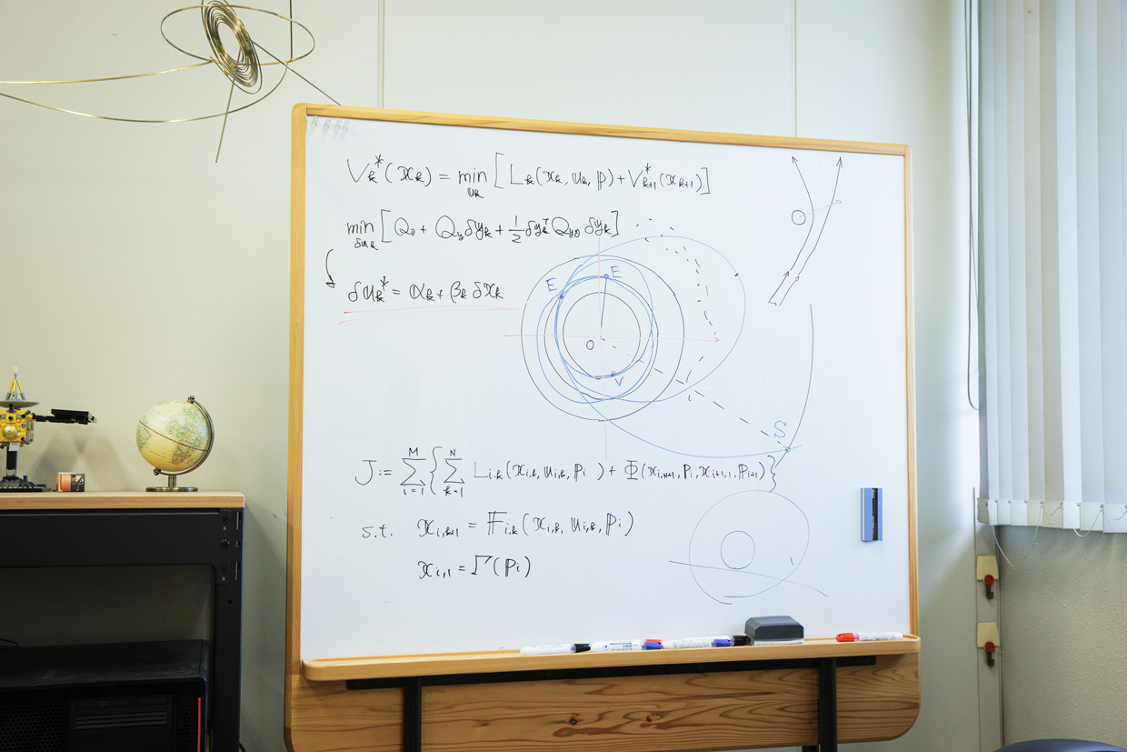 尾崎の研究室のホワイトボードには、軌道設計のための数式が書かれている。