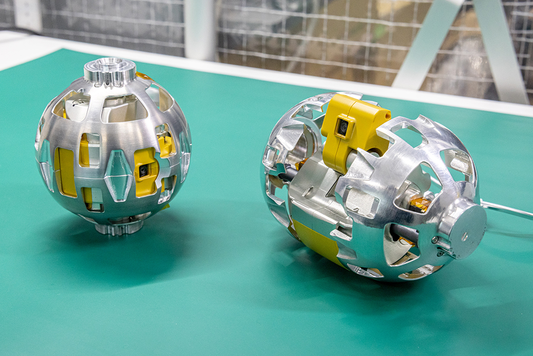 SLIMに搭載された変形型月面ロボット（LEV-2）。愛称は「SORA-Q」。野球ボールとほぼ同じ直径8cmの球形。左が搭載された状態で右が展開後。©︎JAXA/タカラトミー/ソニーグループ(株)/同志社大学