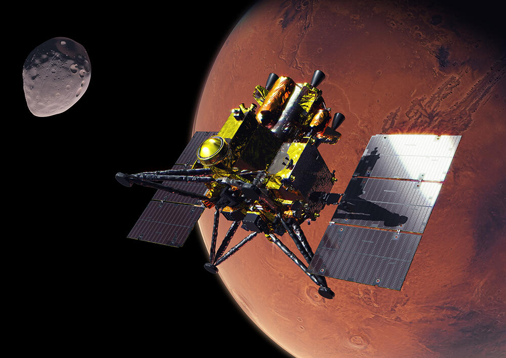 MMX探査機が火星圏に向かうイメージ図。左側に写っている天体が、MMXの目標である火星衛星フォボス。