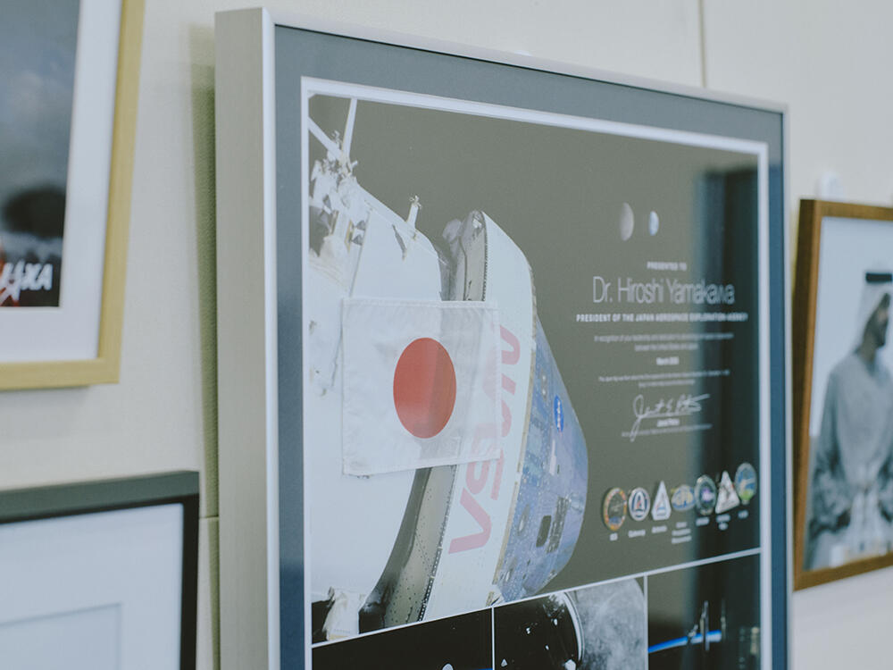 布製の国旗は、3年前に月を目指して打ち上げられたNASAの宇宙船「アルテミス1」に搭載され、地球へ帰還した後、記念品として贈呈されたもの。宇宙機関では、宇宙を旅した品を感謝の証として贈る文化がある。